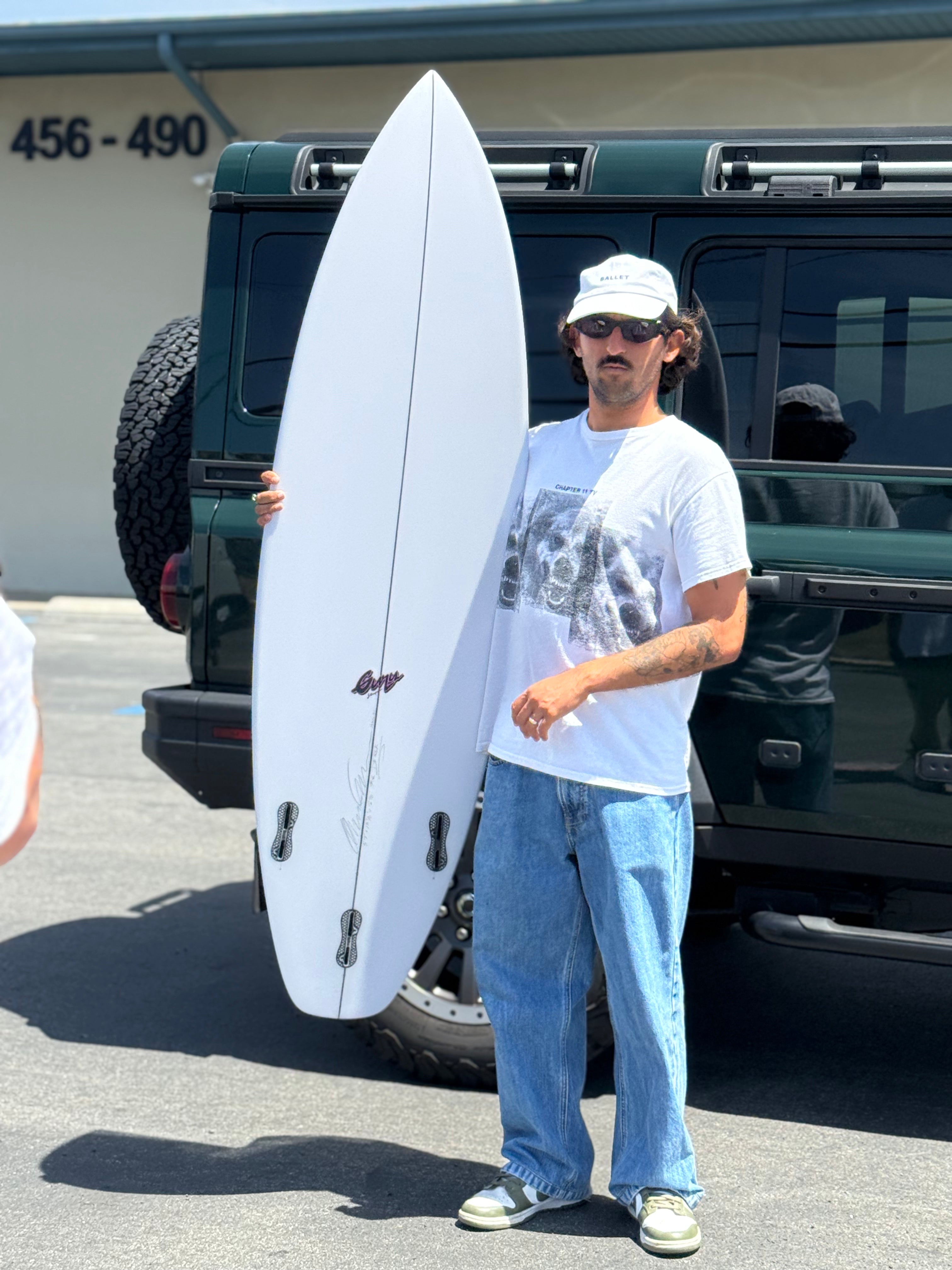 Derek Gomes holding a formula CT surfboard